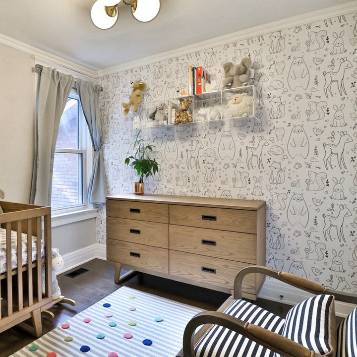 Modern woodland nursery wallpaper with black-and-white forest animals and soft pastel cheeks, ideal for baby rooms, gender-neutral décor, and easy DIY wall updates using peel-and-stick or pre-pasted wallpaper materials.