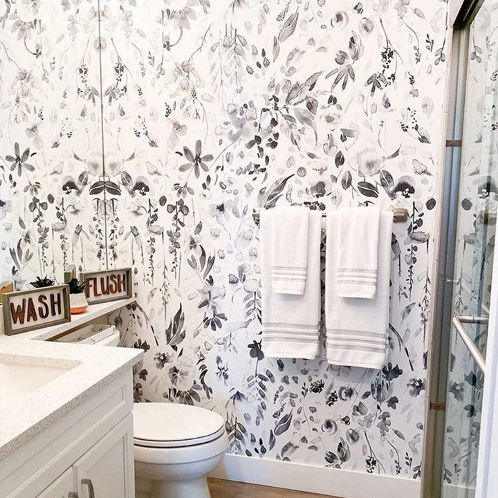 Monochrome botanical wallpaper with hand-painted flowers, vines, and leaves in grayscale watercolor style, available in peel and stick or pre-pasted removable options.