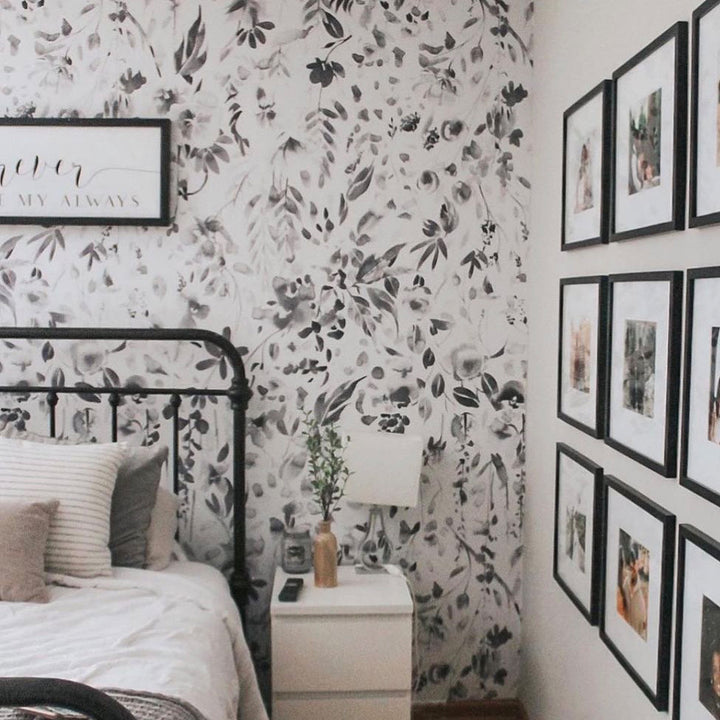 Delicate neutral floral wallpaper with painted wildflowers, vines, and leaf clusters in soft grayscale tones, designed for calm, modern, or Scandinavian-inspired spaces.
