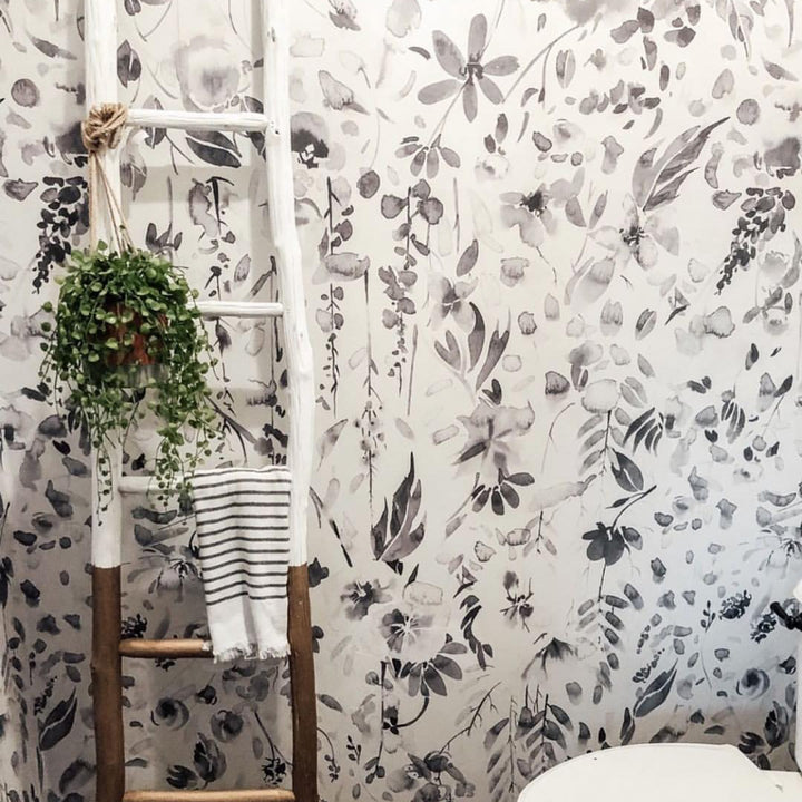 Neutral monochrome botanical wallpaper with delicate wildflower sprays, painted petals, and organic leaf details, ideal for modern nurseries and serene interiors.