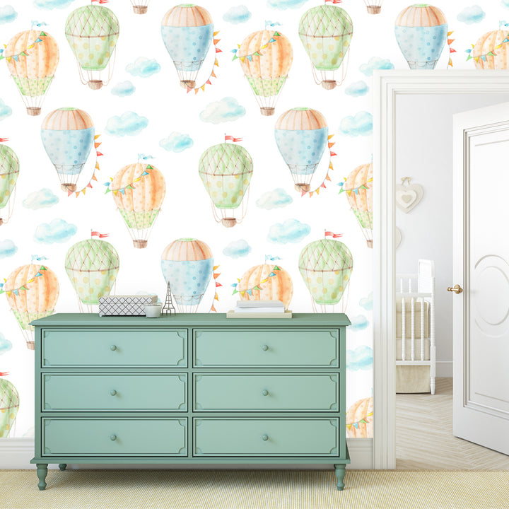 Watercolor hot air balloon wallpaper with pastel balloons and soft clouds on a white background, available as peel and stick or pre-pasted removable wallpaper for nurseries and kids rooms.