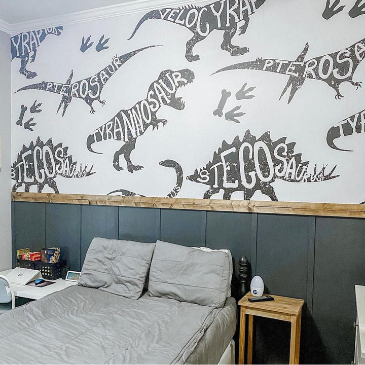 Modern dinosaur typography wallpaper with giant black silhouettes of T-Rex, Stegosaurus and Velociraptor, perfect for boys rooms and themed spaces.