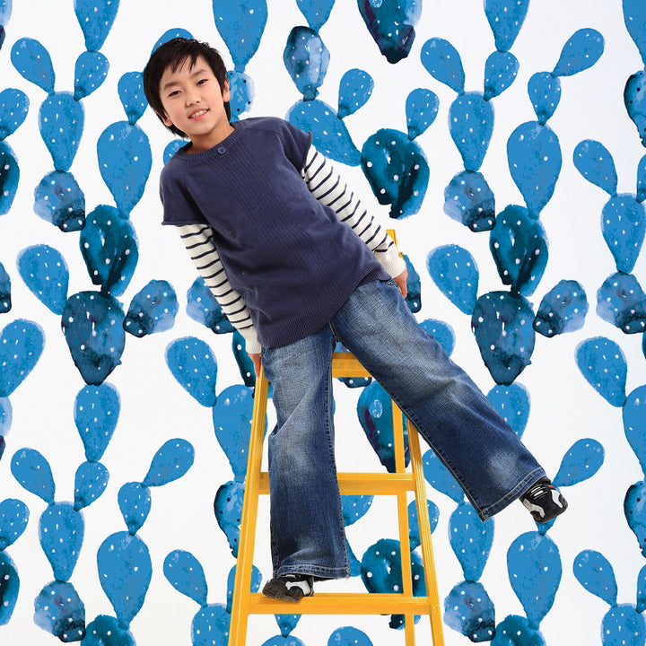 Modern kids’ wallpaper design with watercolor blue cactus pads on a white background, creating a bright desert-inspired look for nurseries, playrooms, or modern children’s bedrooms. Offered in both peel-and-stick and pre-pasted removable options.