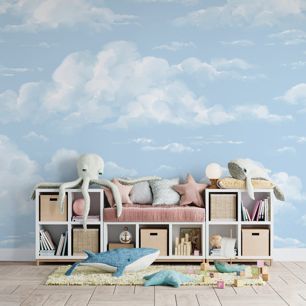 Soft blue sky wallpaper featuring hand-painted fluffy white clouds, printed on removable peel and stick or pre-pasted material for a calm, dreamy nursery or kids room backdrop.
