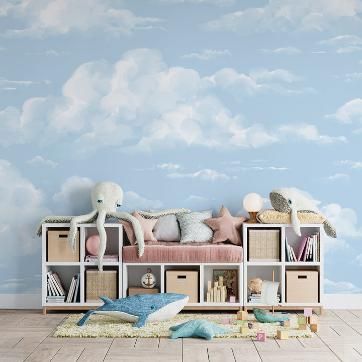 Soft blue sky wallpaper featuring hand-painted fluffy white clouds, printed on removable peel and stick or pre-pasted material for a calm, dreamy nursery or kids room backdrop.