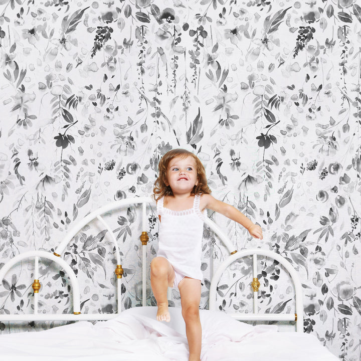 Grayscale watercolor floral pattern featuring layered petals, leafy branches, and gently flowing botanical elements, available as removable peel and stick wallpaper.