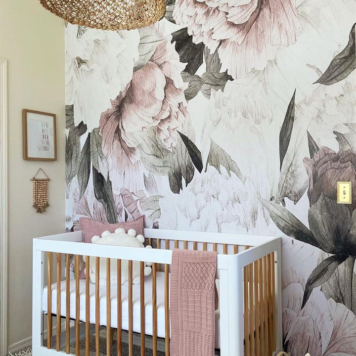 Blush pink oversized peony wall mural featuring soft botanical flowers and greenery, printed on removable peel and stick wallpaper or pre-pasted panels, ideal for nursery décor and feature walls.