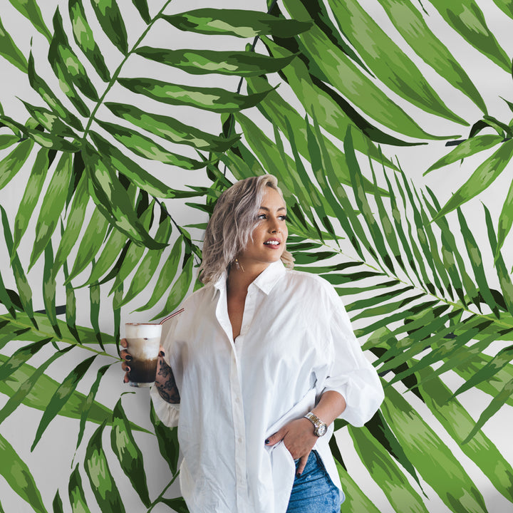 Lush green botanical wallpaper featuring hand-painted palm fronds, tropical-inspired design for living spaces, removable without wall damage.