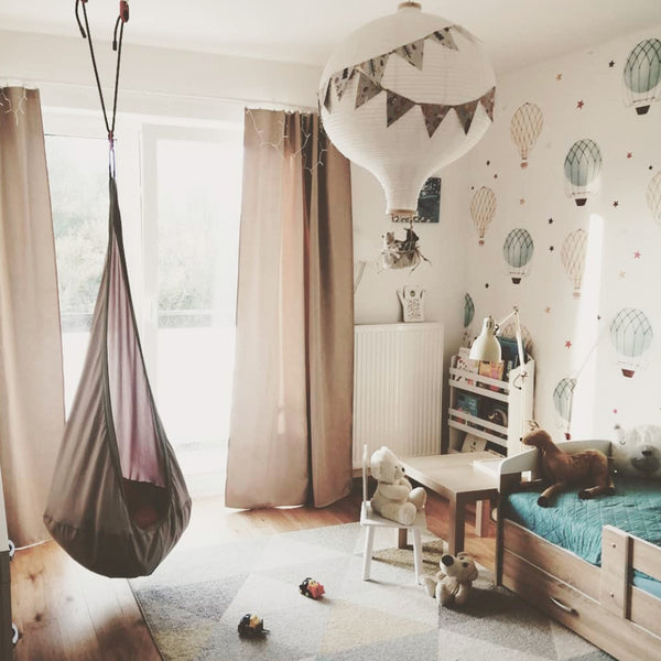 Watercolor hot air balloon wallpaper with pale blue and beige balloons and scattered stars on white background, available in peel and stick or pre-pasted removable material.