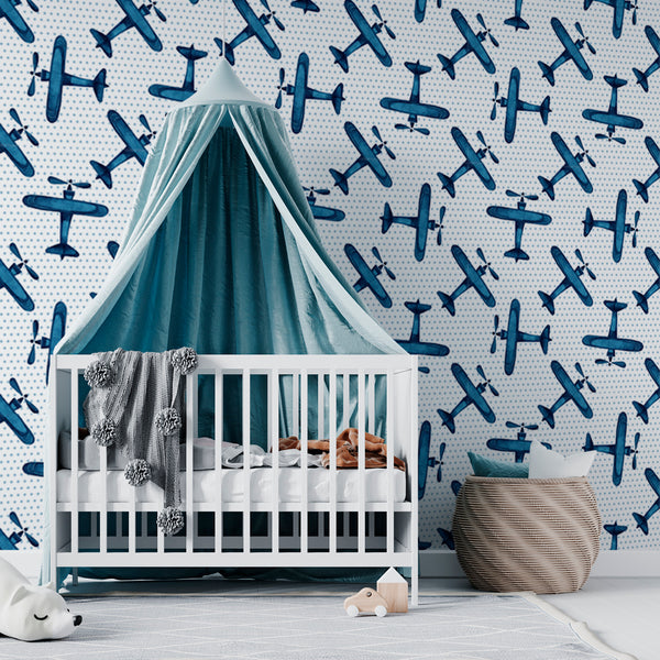 Blue airplane wallpaper featuring repeating vintage-style watercolor planes on a dotted background, designed for kids rooms and nurseries, available in peel and stick or pre-pasted removable material.