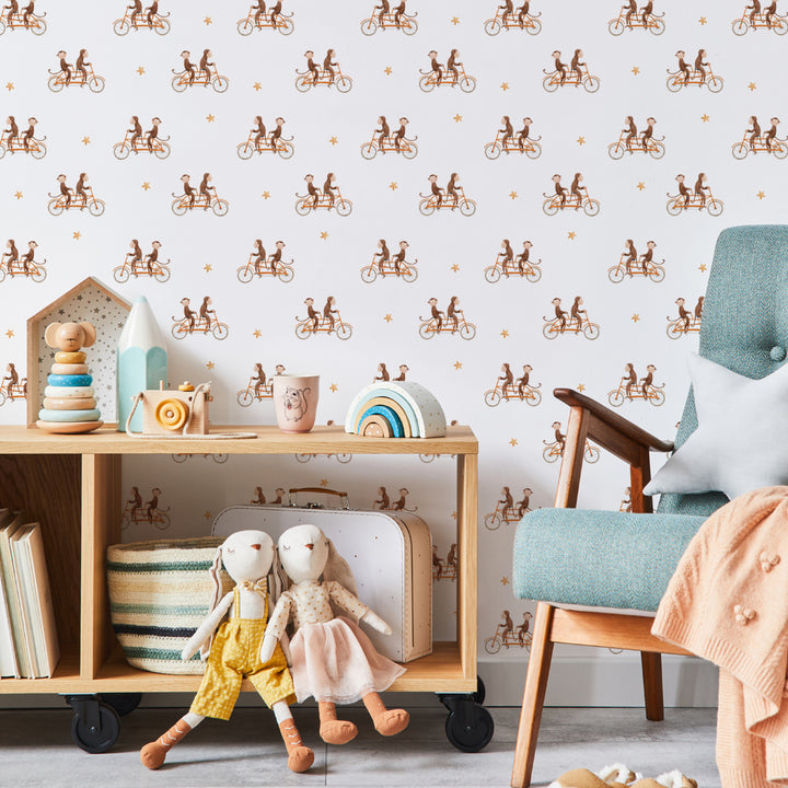 Monkey bicycle ride wallpaper design in soft neutral tones, showcasing adorable monkeys on bikes and orange stars, ideal for fun children’s spaces or gender-neutral nurseries.