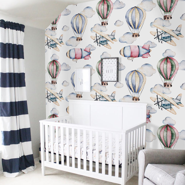 Watercolor hot air balloon wallpaper featuring pastel balloons, clouds, and vintage airplanes on a white background, available in removable peel and stick or pre-pasted material.