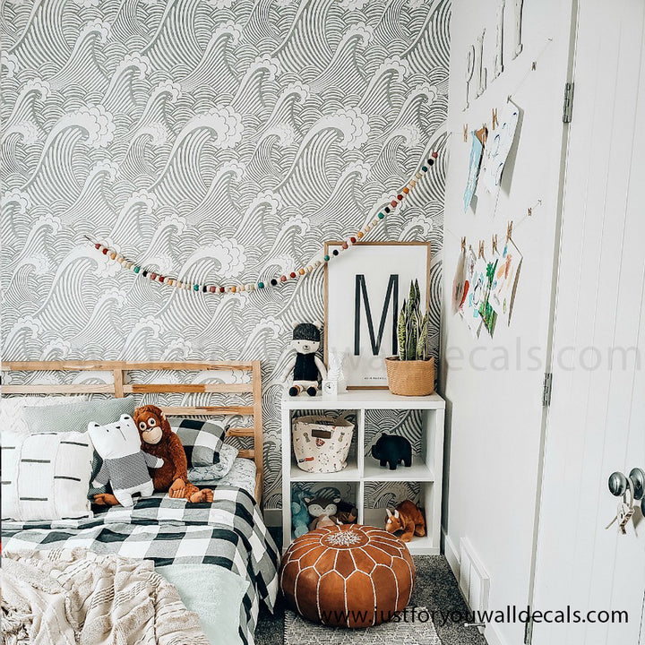 Playful wallpaper with repeating ocean wave patterns in calming blue and white tones. Decorative wallpaper featuring stylized coastal waves, perfect for adding playful charm to any room.