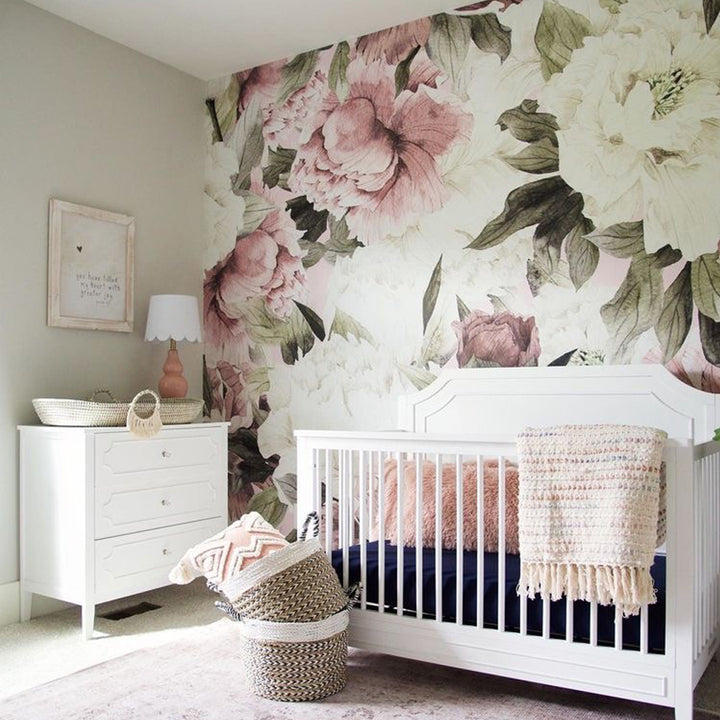 Blush pink oversized peony wall mural featuring soft botanical flowers and greenery, printed on removable peel and stick wallpaper or pre-pasted panels, ideal for nursery décor and feature walls.