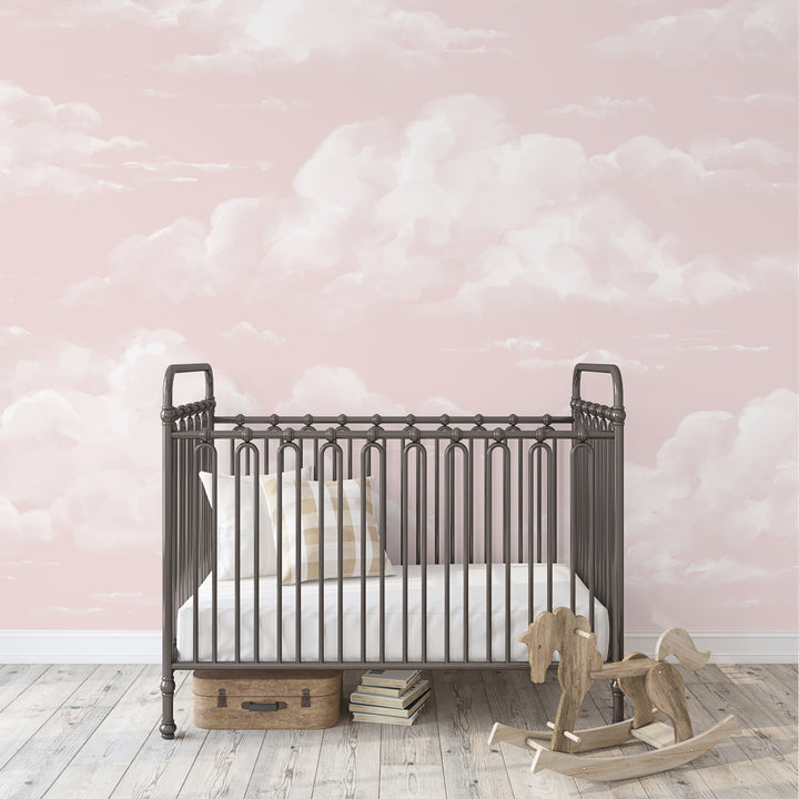 Kids wallpaper featuring soft white clouds on a blush pink sky, designed as removable peel and stick or pre-pasted wallpaper for nurseries and play spaces.
