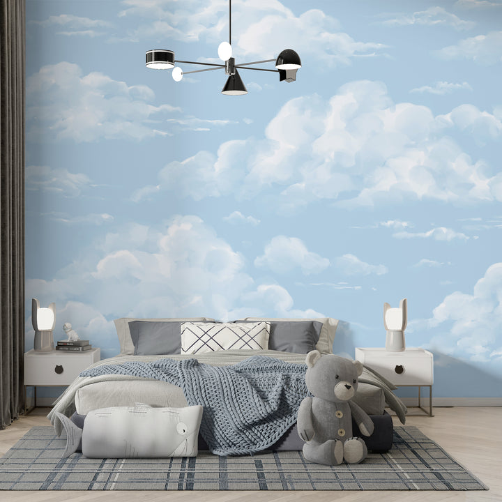 Serene blue sky wallpaper with softly blended white clouds, offered as peel and stick or removable pre-pasted material to create a calm nursery or child-friendly space.