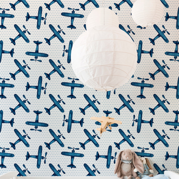 Blue plane wallpaper with soft polka dot background and hand-painted aircraft illustrations, ideal for aviation inspired nursery décor, removable without wall damage.