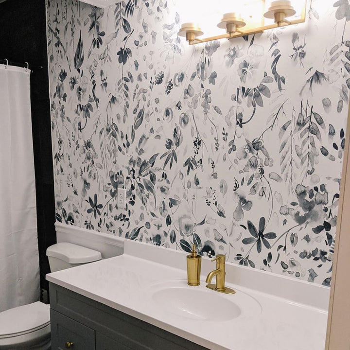 Neutral grey floral wall covering with scattered watercolor wildflowers and leafy stems, designed for nurseries, bedrooms, and calm modern home decor.