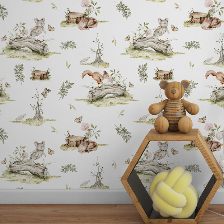 Cottagecore woodland wallpaper with hand-painted animals, flowers, leaves, and logs in a repeating pattern on a light neutral background, perfect for baby nurseries.